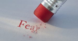 Studio shot of pencil erasing the word fear from piece of paper