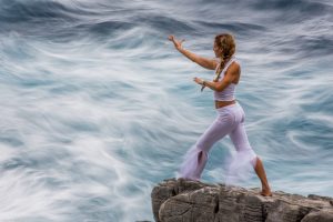 Beth Leone doing qigong on the cliffs of Kardamilli, Greece in an oncoming storm